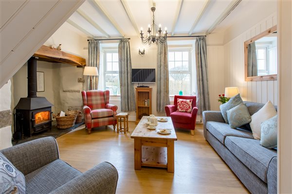 living room in The Farmhouse with glowing log burner